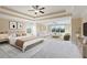 A beautifully staged bedroom featuring tray ceilings, ceiling fans, and views to the outside at 4250 Harrison Lndg, Cumming, GA 30041