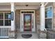 Charming front door with sidelights and transom window, flanked by white columns and manicured landscaping at 4250 Harrison Lndg, Cumming, GA 30041