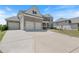 Large concrete driveway leads to the three-car garage of this two-story home with manicured lawn at 4250 Harrison Lndg, Cumming, GA 30041