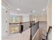Upstairs landing features wrought iron railings, neutral color palette, and a view to downstairs at 4250 Harrison Lndg, Cumming, GA 30041