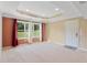 Living Room, showcasing neutral carpet, tray ceiling, large windows and exterior door to backyard at 4250 Harrison Lndg, Cumming, GA 30041