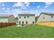 Large backyard with green grass, an outdoor patio seating area, and fencing for seclusion at 814 Lakehaven Ln, Loganville, GA 30052
