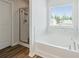 Bright bathroom features a soaking tub with a tile surround, a glass-enclosed shower, and neutral colors at 814 Lakehaven Ln, Loganville, GA 30052