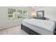 Bright bedroom featuring a large window, soft carpet, and a stylish dark dresser with a mirror at 814 Lakehaven Ln, Loganville, GA 30052