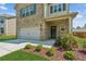 Inviting two-story home features brick accents, a garage, and manicured landscaping at 814 Lakehaven Ln, Loganville, GA 30052