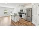 Open-concept kitchen with white cabinets, stainless steel appliances, and a view of the backyard at 814 Lakehaven Ln, Loganville, GA 30052