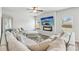 Bright living room with a large gray sofa, a mirror, and a TV over a fireplace at 814 Lakehaven Ln, Loganville, GA 30052