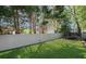 This fenced in back yard has luscious green grass and some mature trees for shade at 8175 Main St, Woodstock, GA 30188