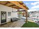 Covered patio with outdoor seating overlooking a pool and grilling area at 8175 Main St, Woodstock, GA 30188