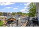 Balcony view features a patio set, overlooks a pool, with nearby commercial building in the background at 8175 Main St, Woodstock, GA 30188
