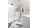 Bathroom featuring a white tile shower, marble floor, and white vanity at 8175 Main St, Woodstock, GA 30188