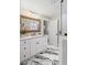Bright bathroom featuring double vanity, marble floors, and glass shower at 8175 Main St, Woodstock, GA 30188