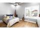 Bright bedroom with hardwood floors, a ceiling fan, and a window letting in natural light at 8175 Main St, Woodstock, GA 30188