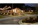 Home exterior featuring professional landscaping, driveway, retaining wall, and elegant lighting at 8175 Main St, Woodstock, GA 30188