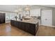 Gourmet kitchen boasts a large island, updated appliances, white cabinetry, and marble countertops at 8175 Main St, Woodstock, GA 30188