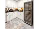 Bright kitchen showcasing white cabinetry, black countertops, and a built-in wine fridge at 8175 Main St, Woodstock, GA 30188