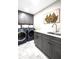 Functional laundry room with gray cabinetry, modern appliances, and stylish tile flooring at 8175 Main St, Woodstock, GA 30188