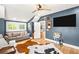 Stylish living room boasts blue walls, hardwood floors, and a large entertainment area at 8175 Main St, Woodstock, GA 30188