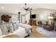 Vaulted ceiling main bedroom features hardwood flooring, TV, seating and lots of natural light at 8175 Main St, Woodstock, GA 30188