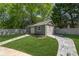 This outbuilding has a garage door, a pedestrian door, and a charming stone-lined walkway at 8175 Main St, Woodstock, GA 30188