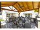 This outdoor kitchen features stainless steel appliances, a covered patio, a fan, and a beautiful stone counter at 8175 Main St, Woodstock, GA 30188