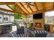 Covered outdoor living area with a fireplace, beverage fridge, built-in grill, and comfortable seating at 8175 Main St, Woodstock, GA 30188