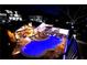 Backyard with in-ground pool, patio with seating, outdoor bar, and well-lit landscaping at 8175 Main St, Woodstock, GA 30188