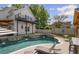 Backyard with a pool, waterfalls, a built-in bar, and lounge chairs for entertaining at 8175 Main St, Woodstock, GA 30188