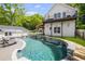 Backyard pool featuring a stacked stone retaining wall and an upper story balcony at 8175 Main St, Woodstock, GA 30188