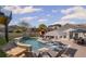 Backyard featuring a pool with a tanning ledge, outdoor kitchen with a covered patio, and lounge seating at 8175 Main St, Woodstock, GA 30188