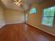 Spacious bedroom featuring vaulted ceilings, wood floors, and three windows providing natural light at 9454 Lakeview Ct, Douglasville, GA 30135
