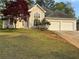 Charming stucco home featuring a two-car garage and a beautifully landscaped front yard at 9454 Lakeview Ct, Douglasville, GA 30135