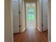 Hallway with wood floors leading to bathroom with soaker tub and natural light at 9454 Lakeview Ct, Douglasville, GA 30135