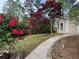 Landscaped yard with beautiful flower bushes and a concrete walkway at 9454 Lakeview Ct, Douglasville, GA 30135