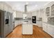 Spacious kitchen featuring an island cooktop, stainless steel appliances, and mosaic backsplash at 105 Laurel Ridge Ct, Fayetteville, GA 30215