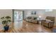 Bright living room featuring hardwood floors, a cozy sofa, and sliding door access to the screened-in patio at 1325 East Forrest Ave, East Point, GA 30344