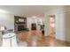 Open floor plan with hardwood floors and a fireplace, connecting the living area to the kitchen and a half-bathroom at 1325 East Forrest Ave, East Point, GA 30344