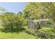 A small metal shed sits in a backyard surrounded by lush trees and greenery, offering practical storage space at 1325 East Forrest Ave, East Point, GA 30344