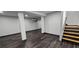 Spacious basement area with sleek flooring, support columns, and a staircase at 185 Glenrose Sw Cir, Atlanta, GA 30354
