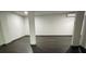 A spacious basement with dark wood-look flooring, support columns, and modern fixtures at 185 Glenrose Sw Cir, Atlanta, GA 30354
