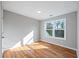 Bright bedroom features hardwood floors, base trim, flush mount lighting, and window at 3180 Tackett Rd, Douglasville, GA 30135