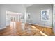 Open-concept living room featuring hardwood floors, white walls, many windows and access to the kitchen at 3180 Tackett Rd, Douglasville, GA 30135