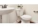 A bright bathroom features a pedestal sink, toilet, and white molding at 3570 Terrasol Sw Trl, Lilburn, GA 30047