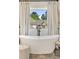 Luxurious soaking tub by a window with white drapes and a neighborhood view at 1395 Oconee Ne Pass, Brookhaven, GA 30319