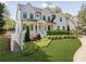 Charming two-story white home featuring a lush green lawn and meticulously landscaped front yard at 1395 Oconee Ne Pass, Brookhaven, GA 30319