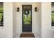 Elegant front door framed by stylish sconces and a decorative wreath, set against a white brick facade at 1395 Oconee Ne Pass, Brookhaven, GA 30319