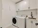 Efficient laundry room with modern washer, dryer, and built-in cabinetry at 1395 Oconee Ne Pass, Brookhaven, GA 30319