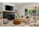 Bright living room featuring a fireplace, hardwood floors, and comfortable seating with backyard view at 1395 Oconee Ne Pass, Brookhaven, GA 30319