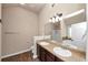 Bright bathroom featuring dual sinks with dark cabinets and wood-look floors at 2375 Walker Dr, Hampton, GA 30228