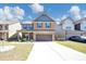 Charming two-story brick home with a welcoming front porch and a well-manicured lawn at 2375 Walker Dr, Hampton, GA 30228